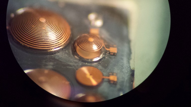 View through a microscope of microcoils developed in the Tadigadapa lab. Each coil, made of copper patterned on glass, creates a magnetic field that produces an electric current in targeted brain cells.
