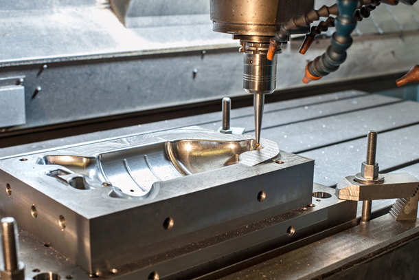 A machine cuts a metal mold